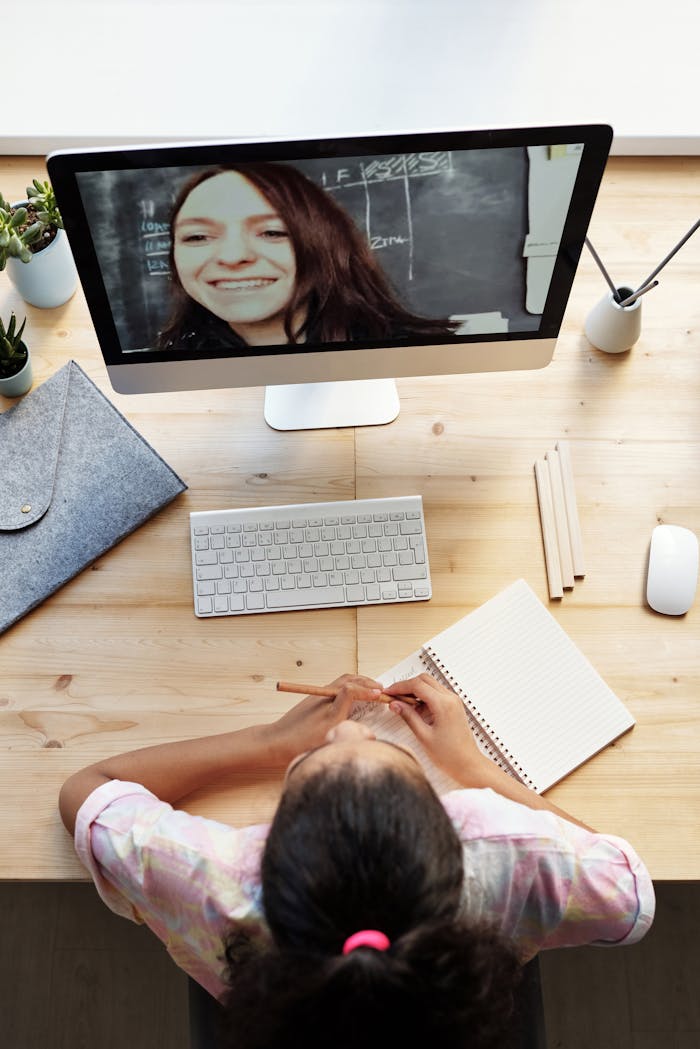 Top View Photo of Girl Watching Through Imac